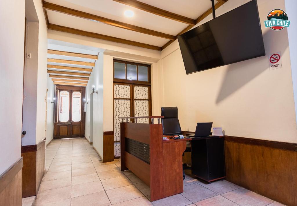 an office with a reception desk and a tv on the wall at Viva Chile Santiago Centro in Santiago