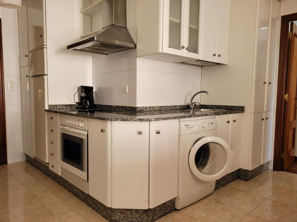 a kitchen with a washing machine and a sink at Piso Alameda Carballiño in Carballino