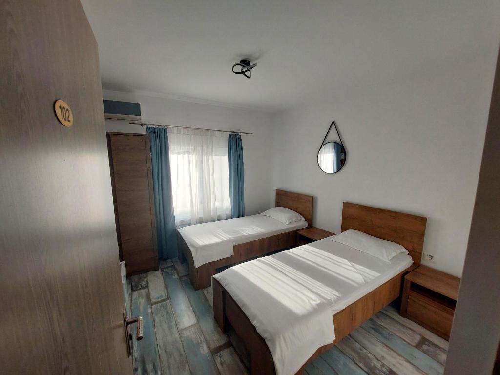 una piccola camera con due letti e una finestra di SeaHorse GuestHouse a Năvodari