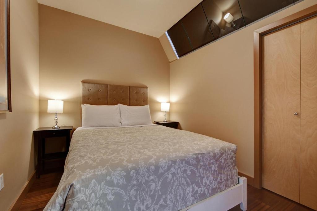 Cette petite chambre comprend un lit et deux lampes. dans l'établissement Heart Of Downtown Victoria, à Victoria