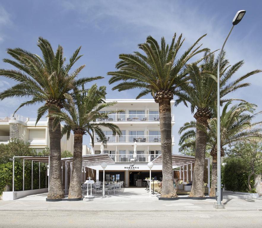 een groep palmbomen voor een gebouw bij Cabot Romantic- Adults Only in Port de Pollença