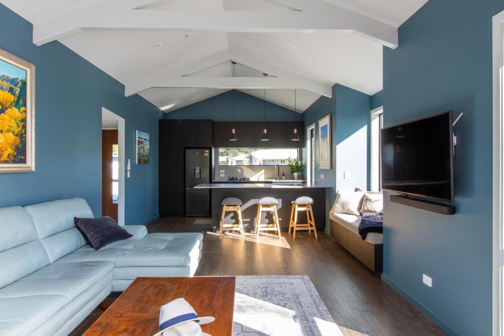 een woonkamer met een witte bank en blauwe muren bij Silvan Forest Pod 2 in Richmond