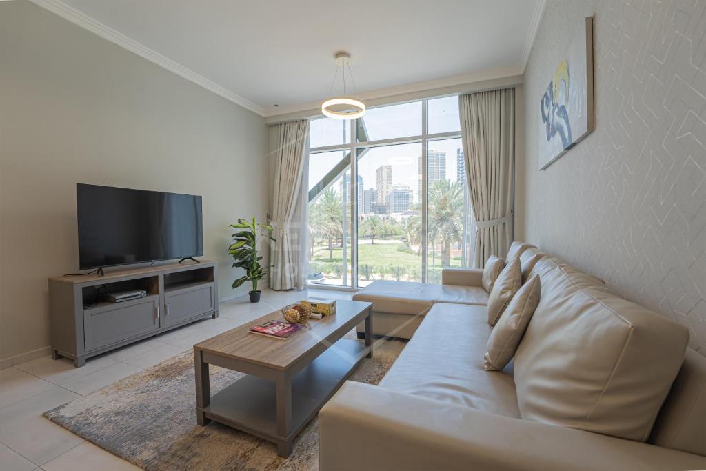 a living room with a couch and a tv at KeyHost - Regent Court JVC - K180 in Dubai