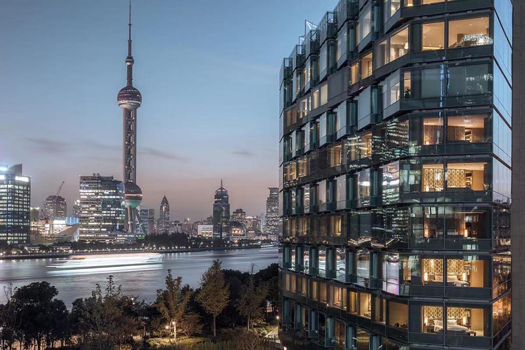 um edifício de apartamentos alto com vista para um rio em Banyan Tree Shanghai On The Bund em Xangai