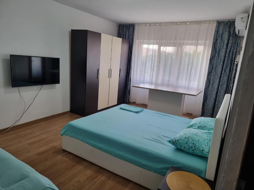 a small bedroom with a bed and a television at Rozelor in Mangalia