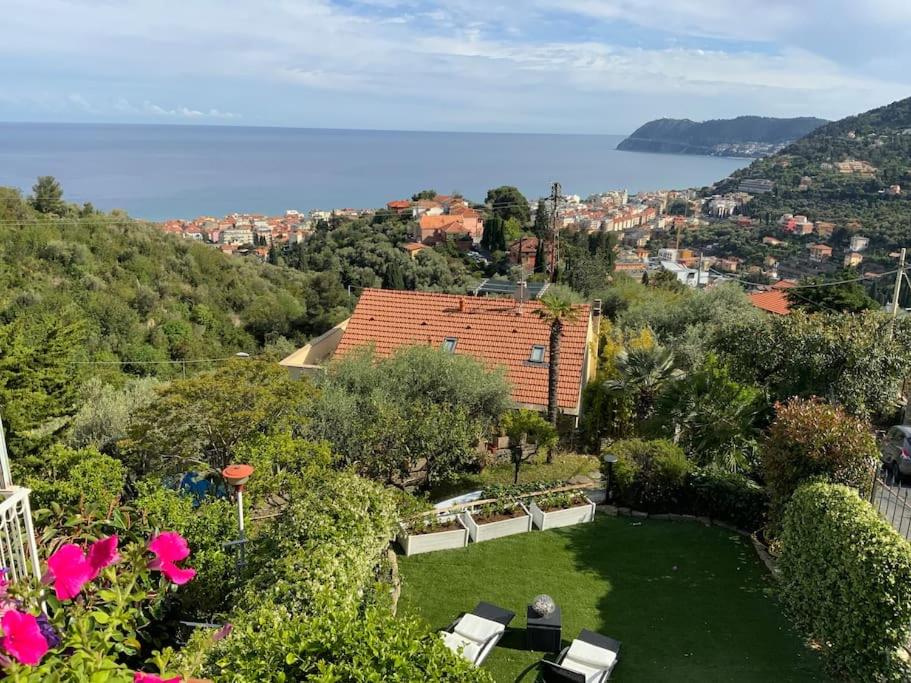 a garden with chairs and a view of the water at Ca Bea in Alassio