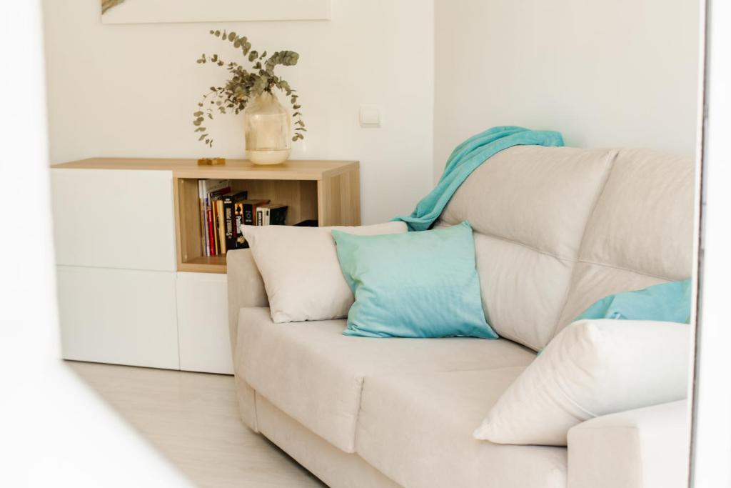 a white couch with pillows on it in a living room at Dalex in Salou