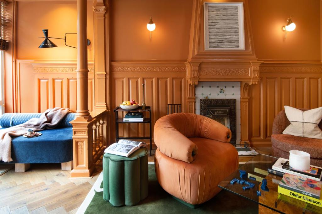 a living room with a chair and a fireplace at Jan Luyken Amsterdam in Amsterdam