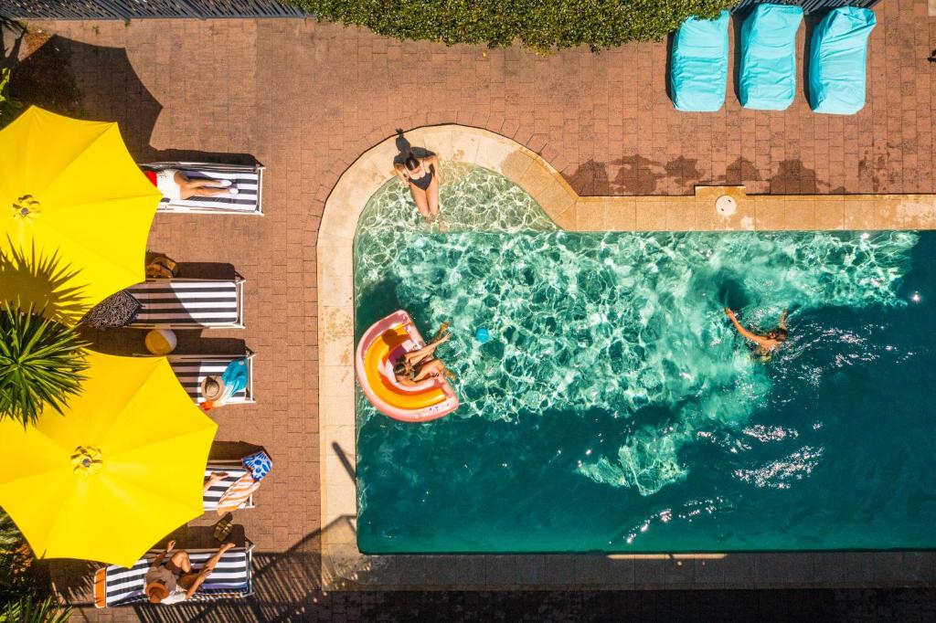 an overhead view of a pool with people swimming in it at YHA Byron Bay in Byron Bay