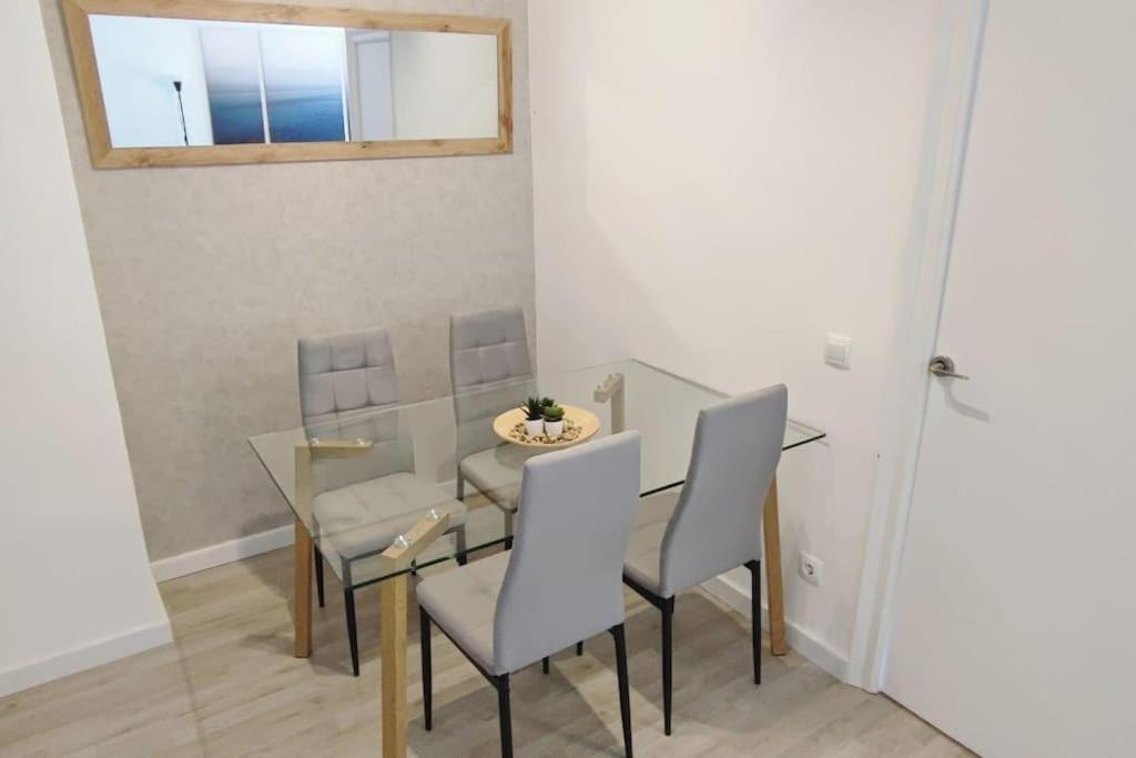 ein Esszimmer mit einem Tisch, Stühlen und einem Fenster in der Unterkunft Piso nuevo a 2 minutos de la playa in Sant Feliu de Guixols
