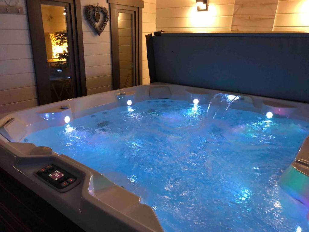 a jacuzzi tub with lights in a room at Jacuzzi - BBq - Jardin - Garden Lodge - Le Tulipier in Olne