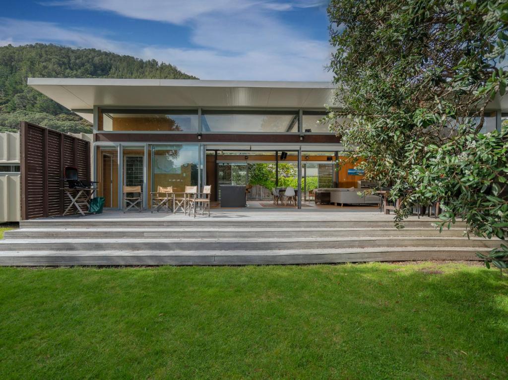 a modern house with glass doors and a porch at Little Paua - Pauanui Holiday Home in Pauanui