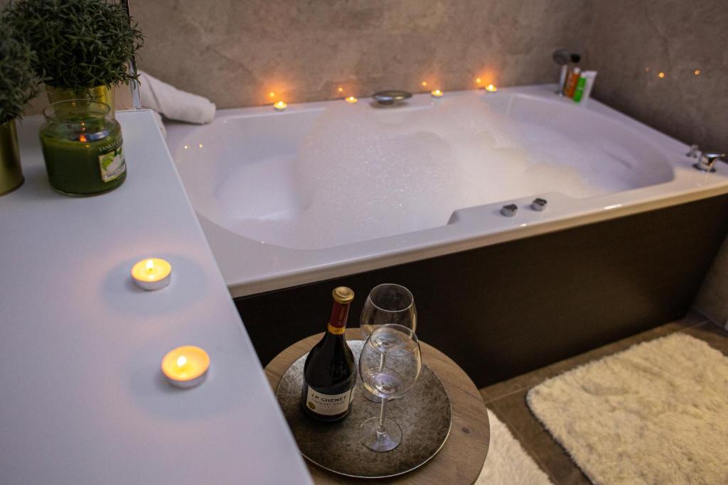 a bath tub with a bottle of wine and two glasses at Galaxy Apartments in Belgrade