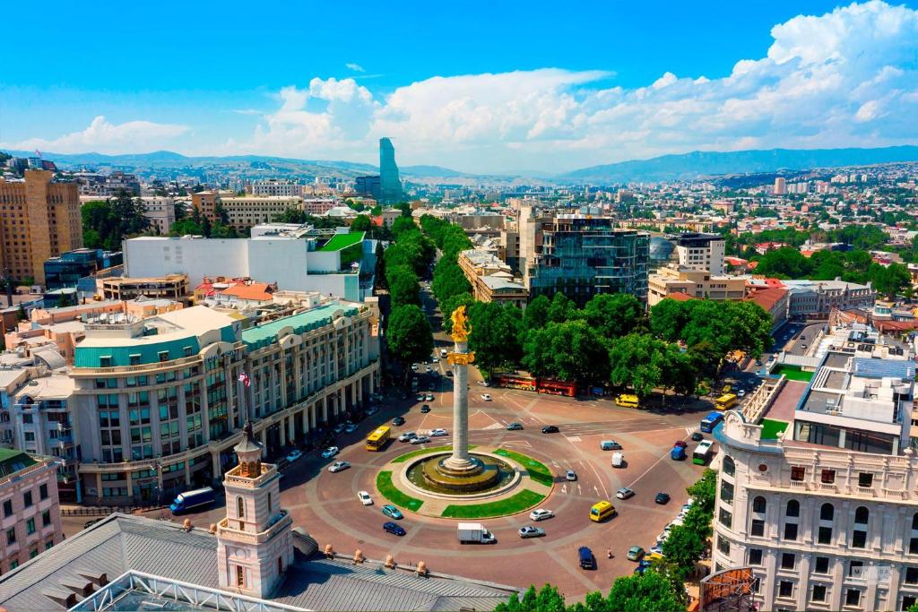 eine Luftansicht einer Stadt mit einem Denkmal in der Unterkunft HH Hotel in Tbilisi City