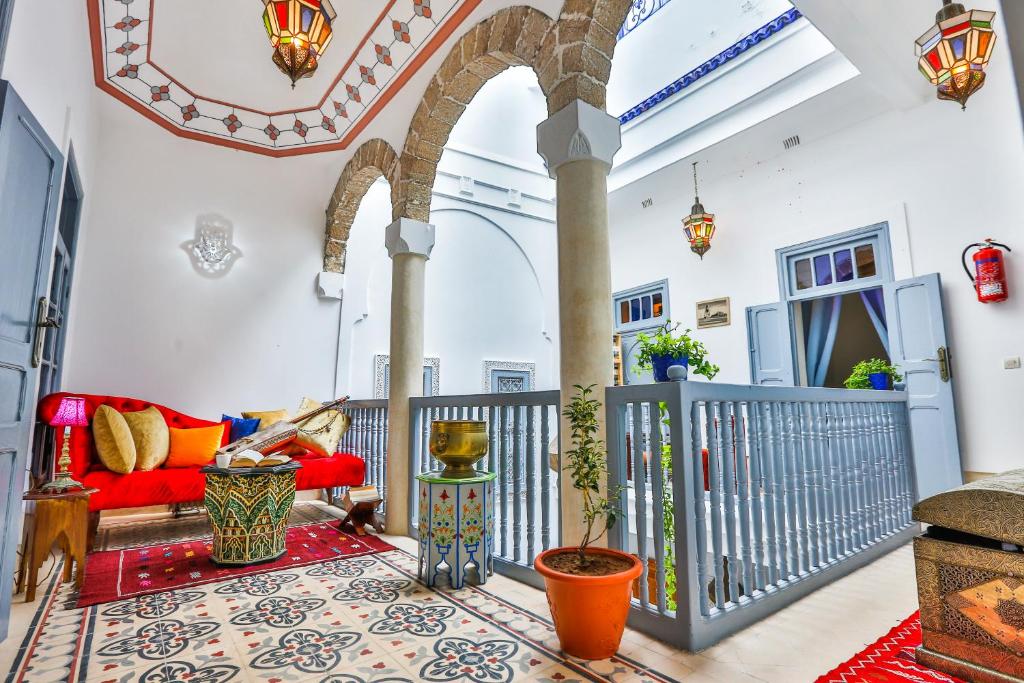 a living room with a red couch and a balcony at Riad Alech in Essaouira