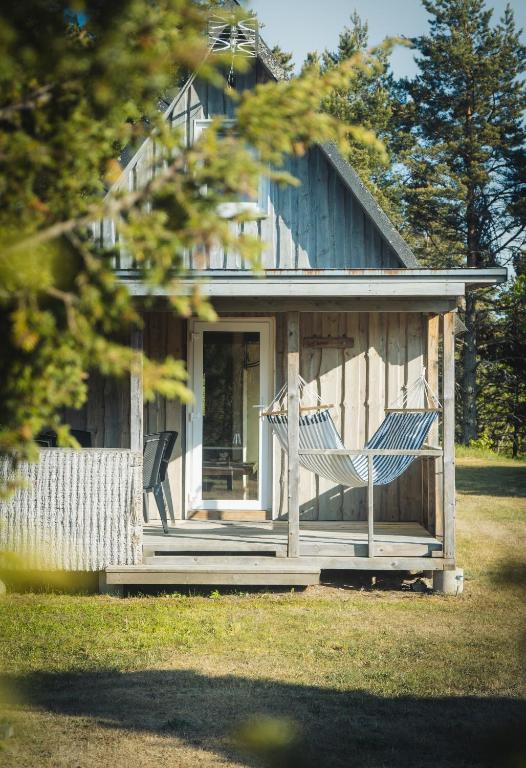 a house with two chairs on the front porch at Männiliiva puhkemaja in Hiiumaa