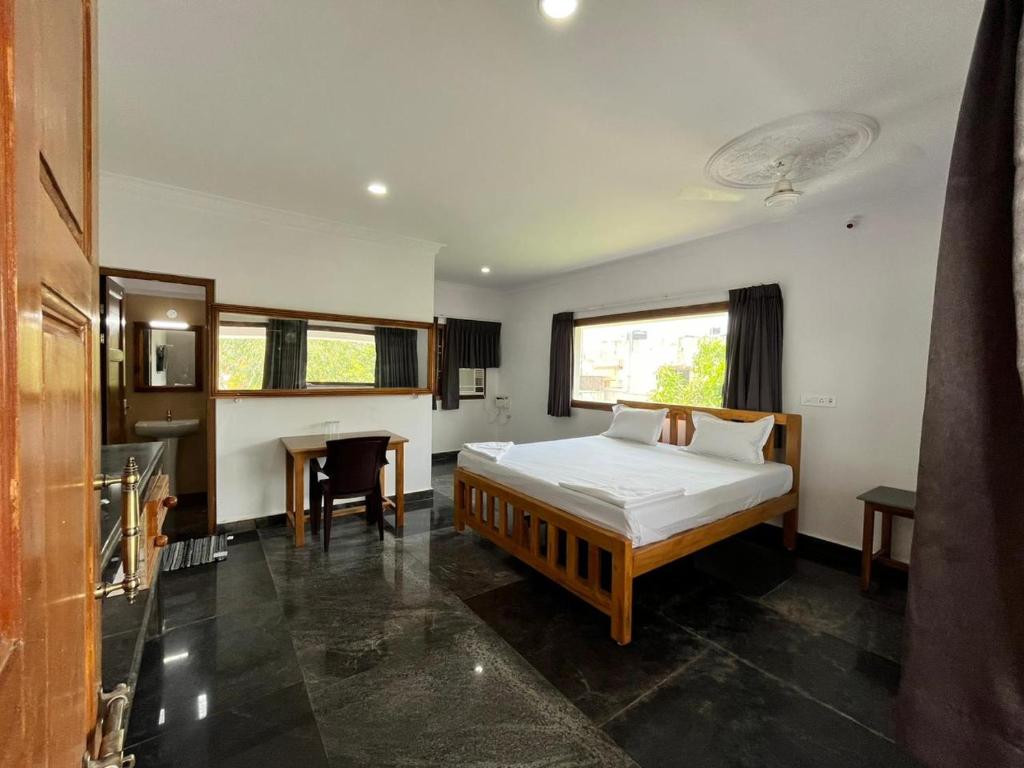 1 dormitorio con cama y escritorio. en ANAND Beach Guesthouse by Moonrocks, en Mahabalipuram