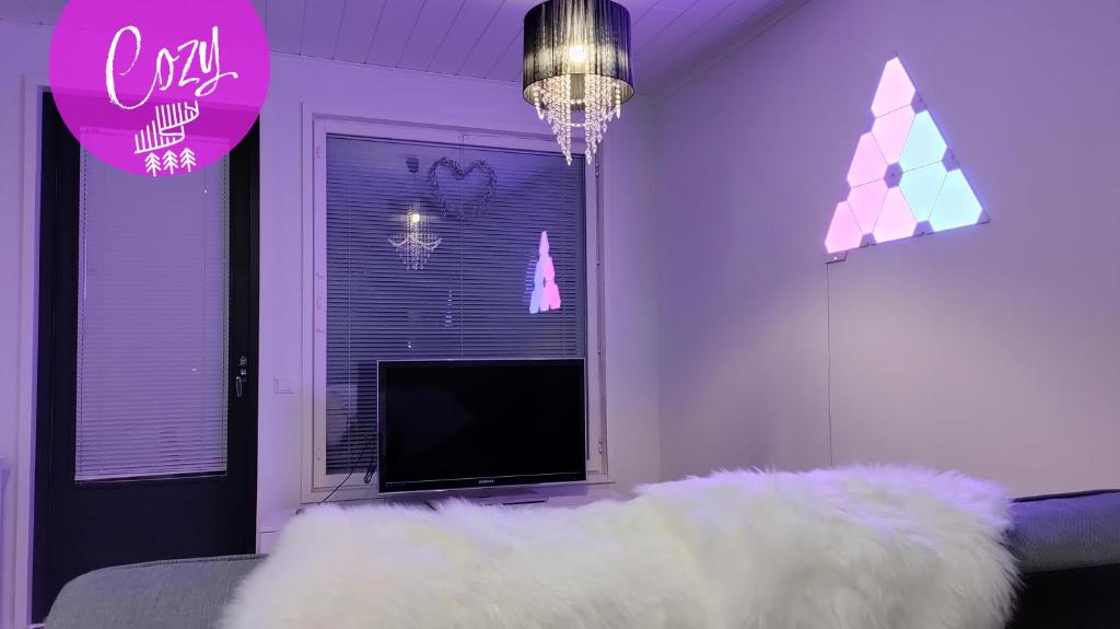 sala de estar con TV y sofá blanco en Northern Lights - Cozy apartment, en Kalajoki