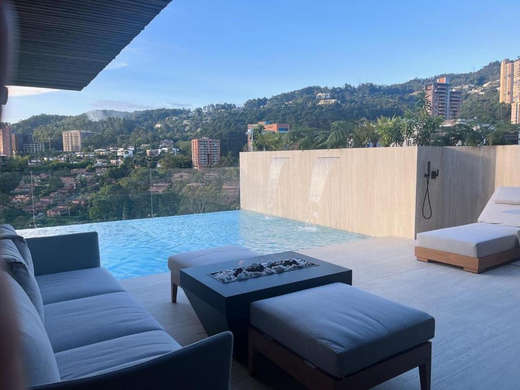 ein Wohnzimmer mit Poolblick in der Unterkunft Binn Hotel in Medellín