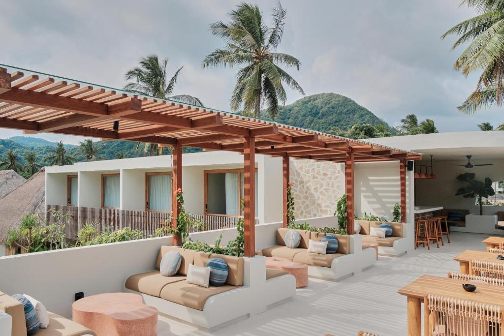 eine Terrasse im Resort mit Sofas und Tischen in der Unterkunft Boni Beach Lombok Boutique Hotel in Selong Belanak