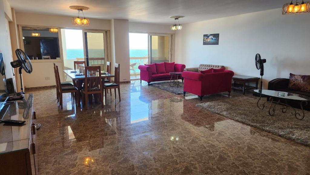 uma sala de estar com cadeiras vermelhas e uma mesa em Sea View Heart Apartment (families only) em Alexandria