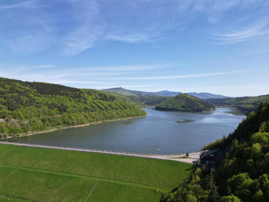 vistas a un lago con un puente a lo lejos en Mountain Cozy Home, en Sub Cetate