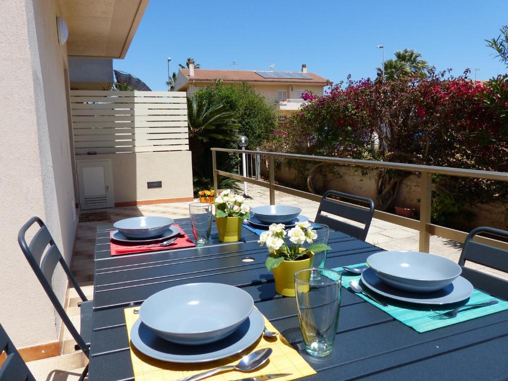 una mesa azul con platos y platos en el balcón en siciliacasevacanze - Villa Venere, en Marina di Ragusa