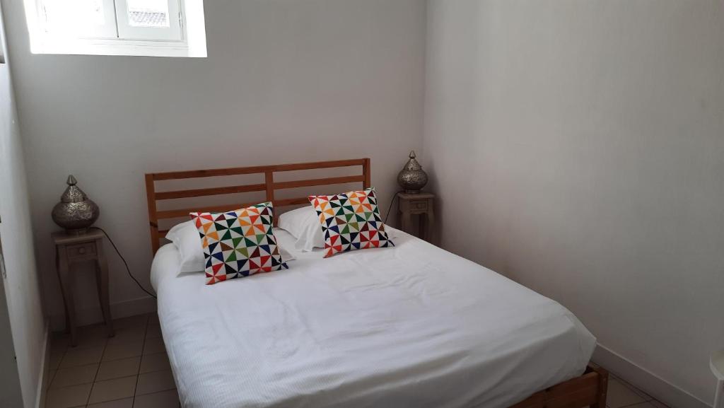 a bedroom with a bed with two pillows on it at La Mansarde in Saint-Émilion