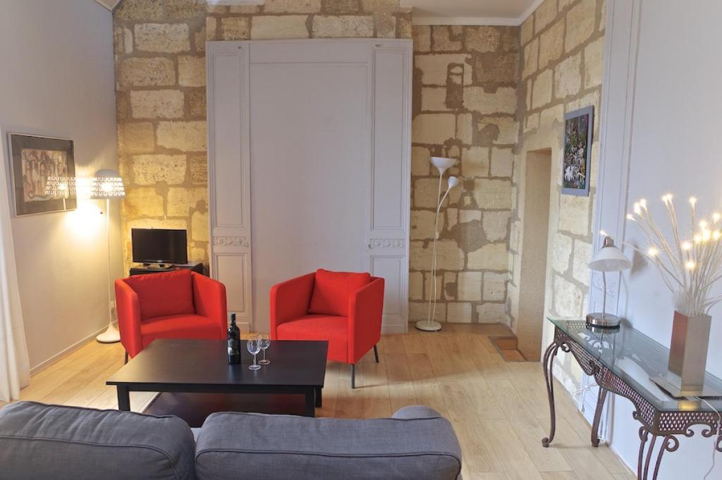 a living room with two red chairs and a couch at Chartres - Appartement 1 chambre avec ascenseur in Bordeaux