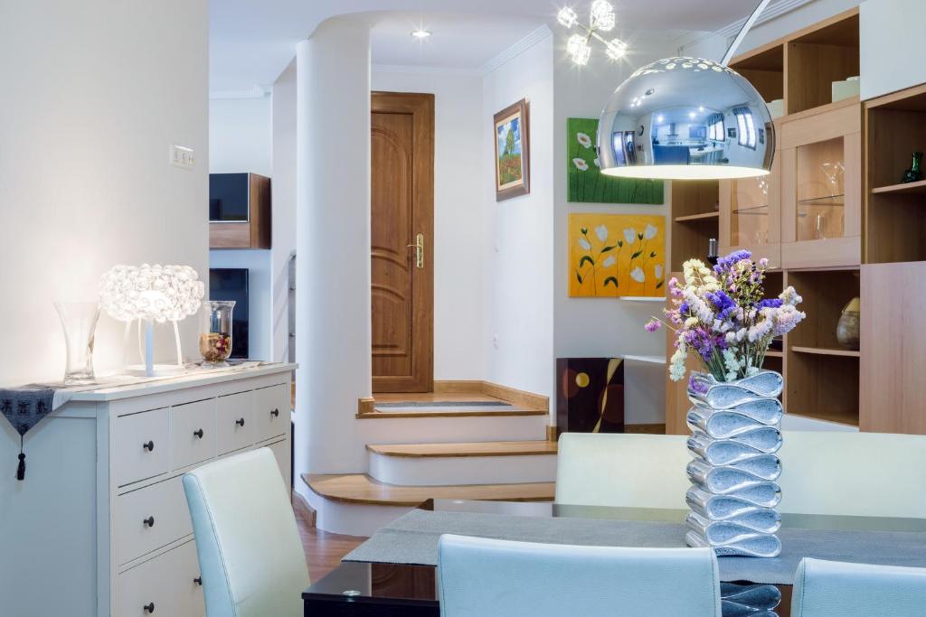a dining room with a table and a vase of flowers at Apartamento céntrico Candás in Candás