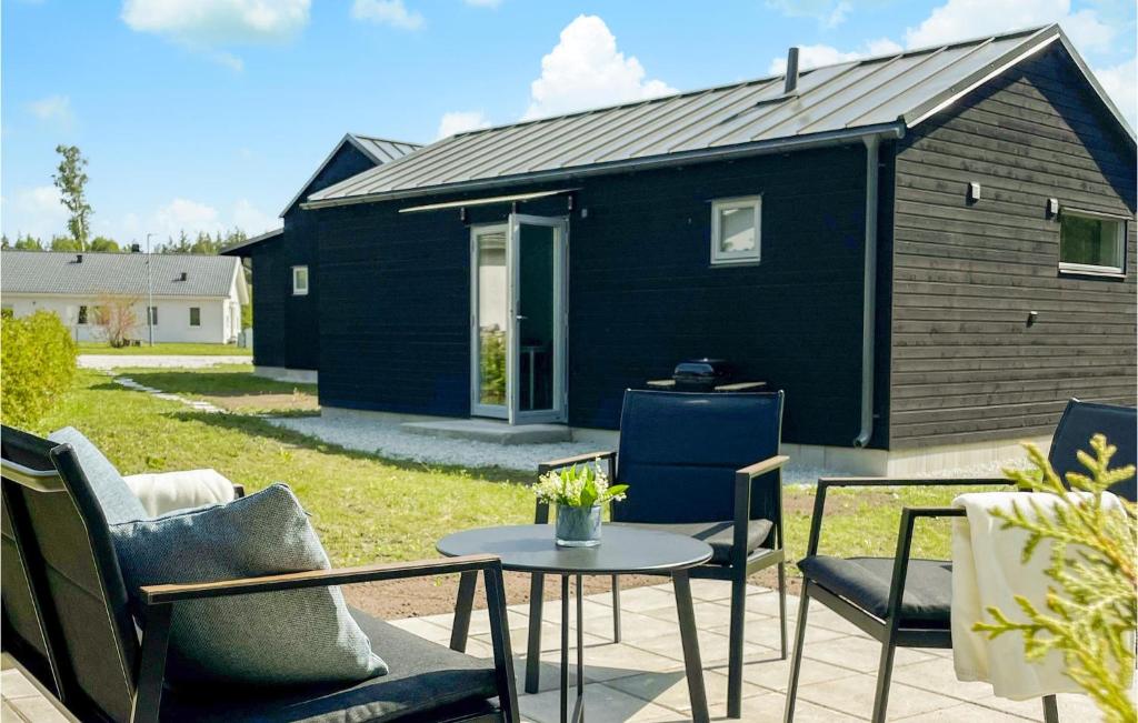 una pequeña casa negra con mesa y sillas en 2 Bedroom Awesome Home In Gotlands Tofta, en Västergarn