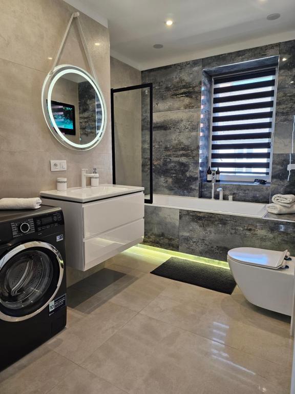 a bathroom with a washer and dryer in it at Galaxy Apartments 2 in Słupsk