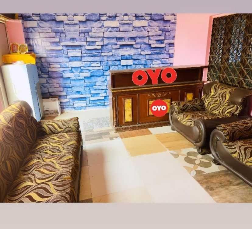 sala de estar con 2 sofás frente a una pared de ladrillo en POP Radhe Oyo Hotel, en Manesar