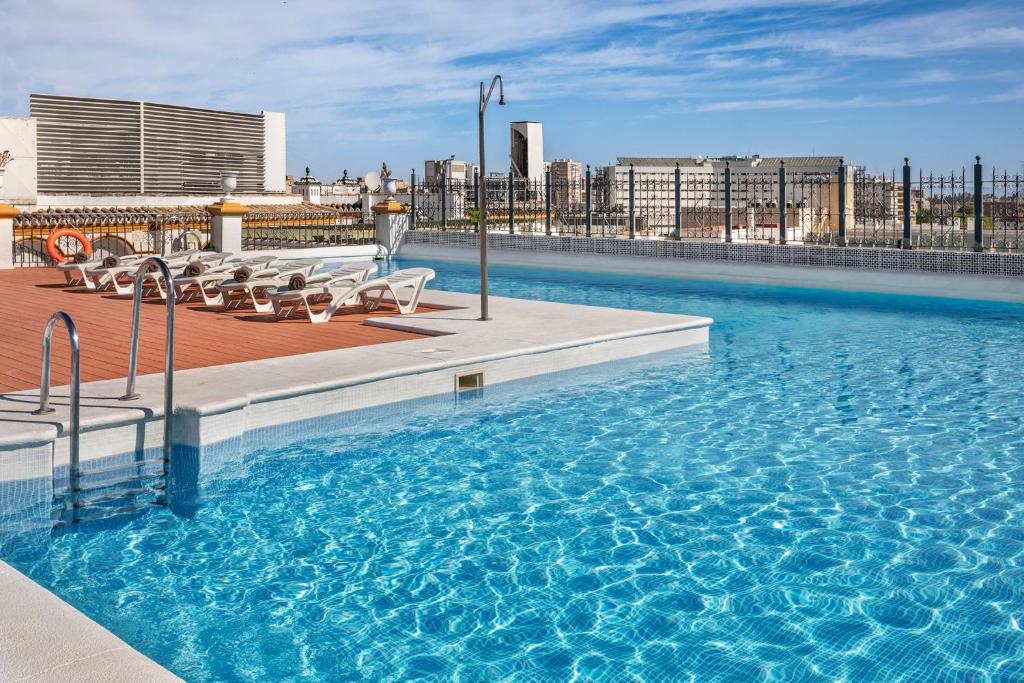 a large swimming pool on top of a building at Exe Sevilla Macarena in Seville