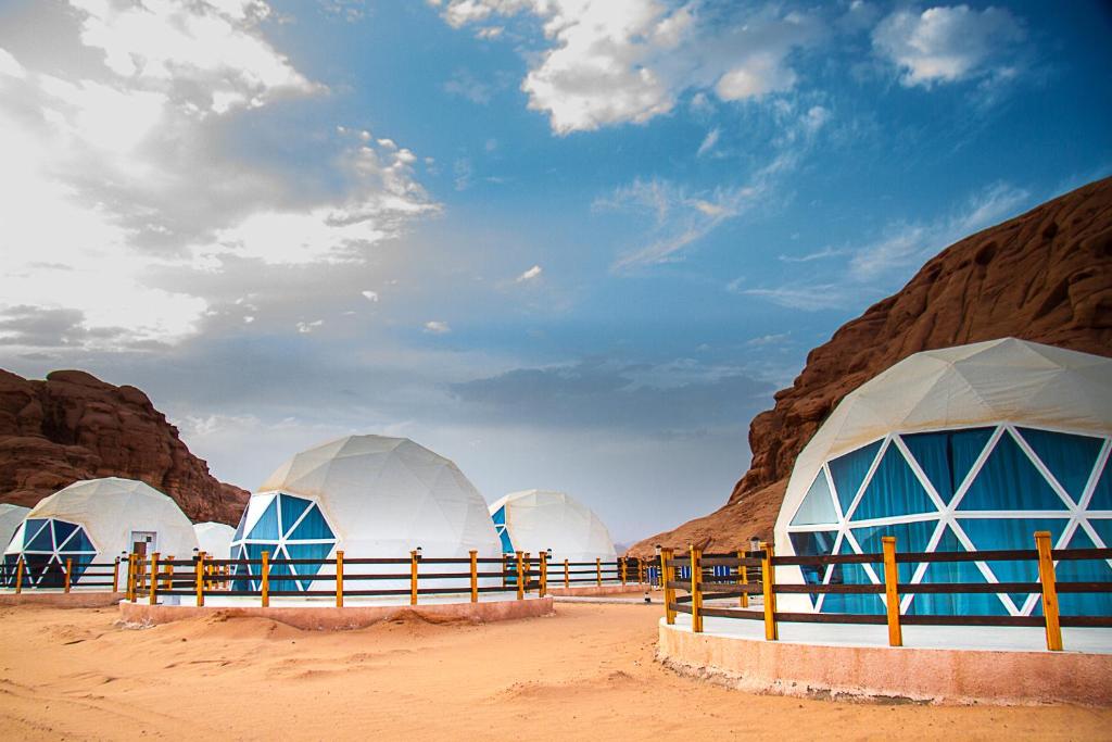 a group of domes in the desert next to some rocks at Desert Season Camp in Wadi Rum