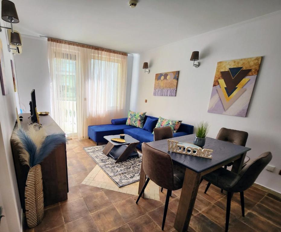 a living room with a blue couch and a table at Синьо лято /Blue summer in Sunny Beach