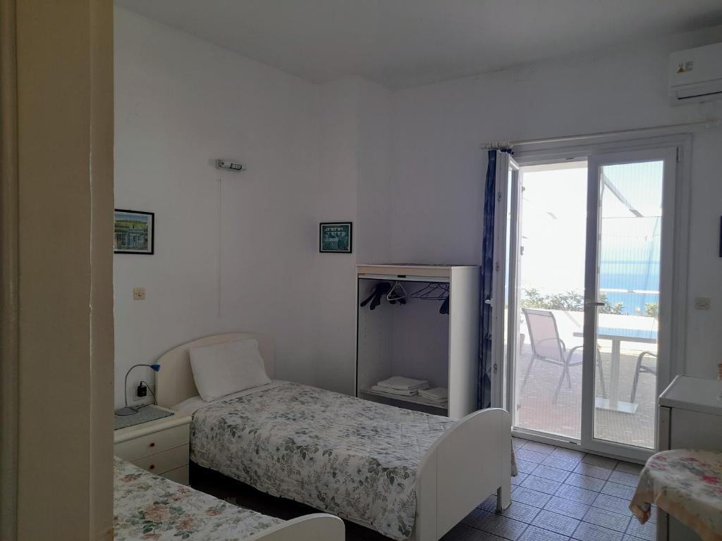 sypialnia z 2 łóżkami i przesuwnymi szklanymi drzwiami w obiekcie Varagoulis Giannis & Lenas Apartments w mieście Paramonas