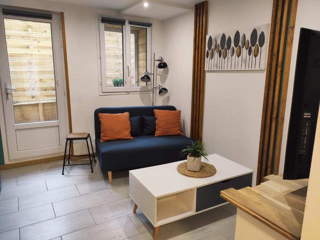 sala de estar con sofá azul y mesa en Studio spacieux aux portes de la Camargue en Beauvoisin