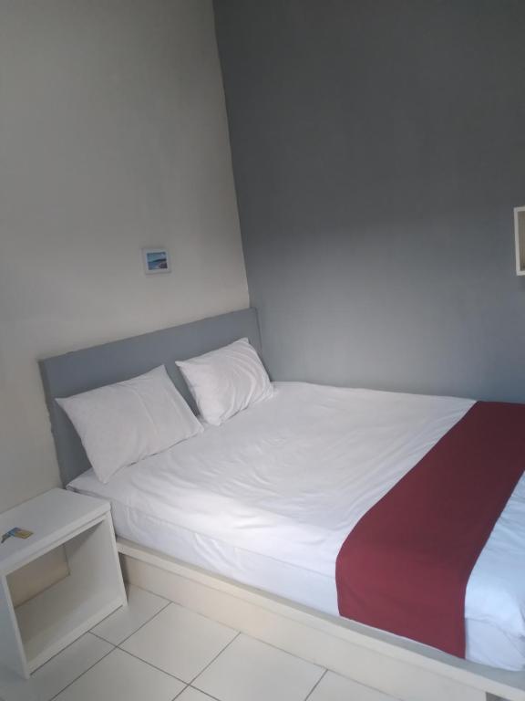 Postel nebo postele na pokoji v ubytování Poppies Senggigi Hostel