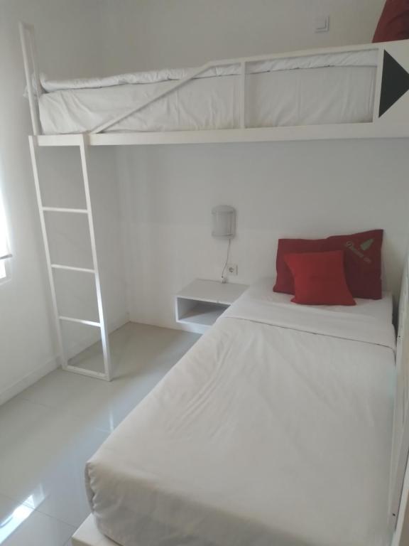 Postel nebo postele na pokoji v ubytování Poppies Senggigi Hostel