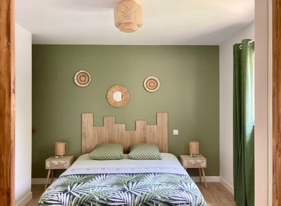 um quarto com uma cama e uma parede verde em Maison neuve à deux pas du Mont em Beauvoir