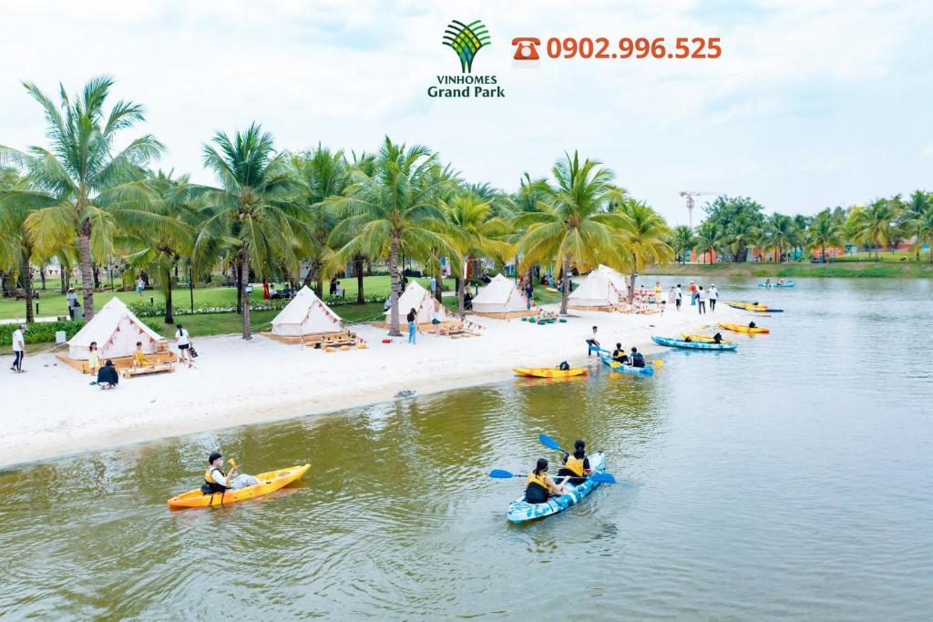 a group of people on kayaks in the water near a beach at Vinhomes Grand Park Quận 9-Bống House in Long Bình