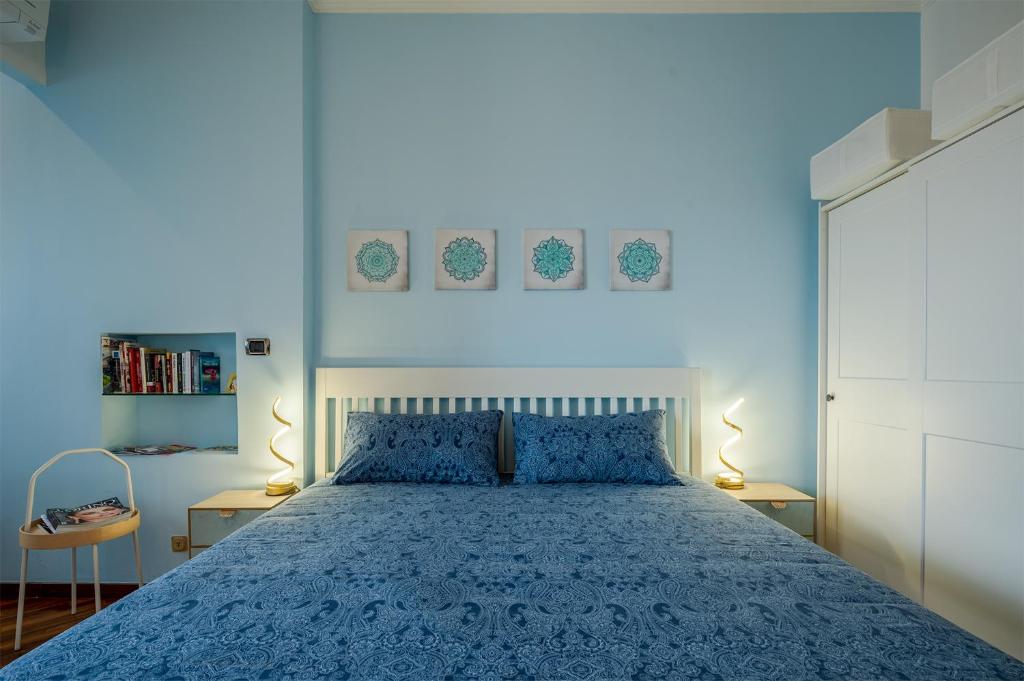 um quarto azul com uma cama com uma colcha azul em Un Buon Inizio em Turim