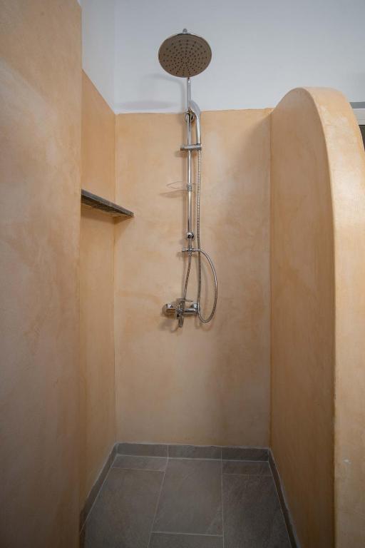 a shower with a shower head hanging from the wall at Alcyone in Serifos Chora