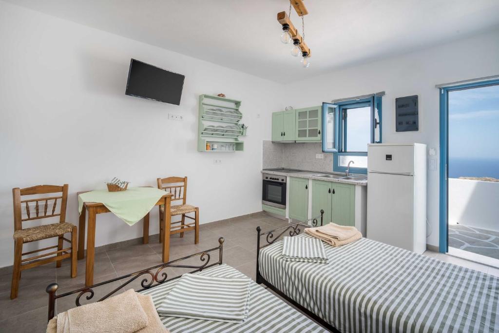 a kitchen with two beds and a table and a table and chairs at Alcyone in Serifos Chora