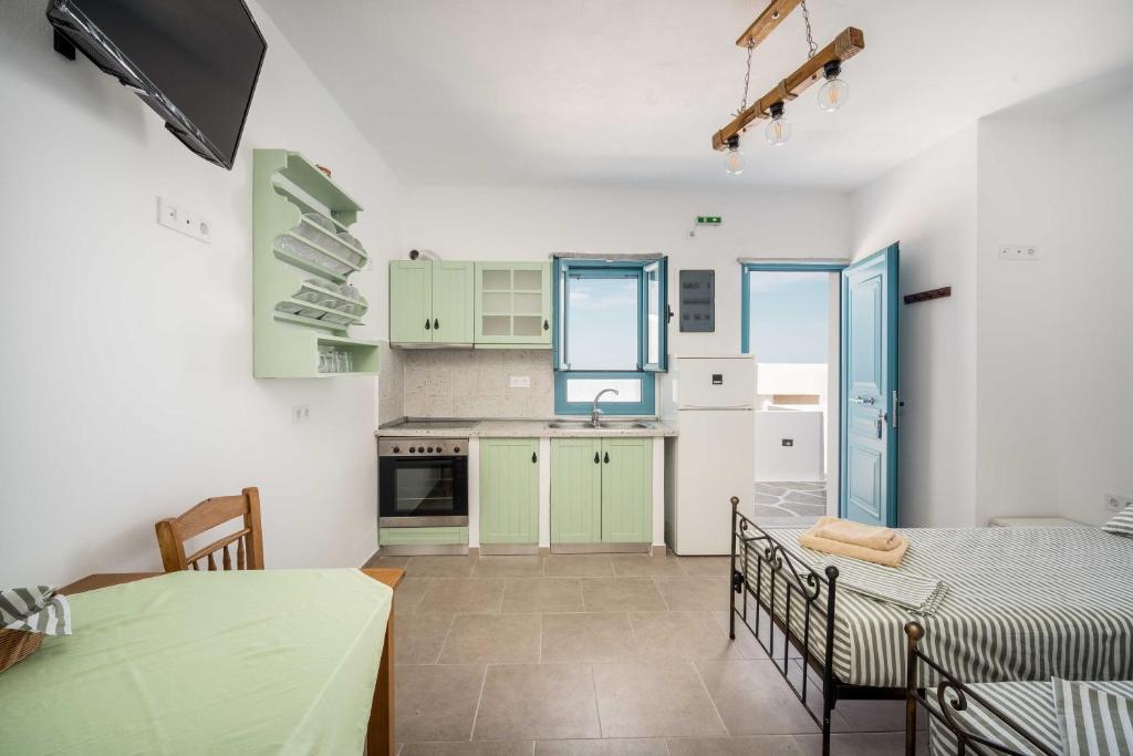 une cuisine et une salle à manger avec une table, une table et des chaises dans l'établissement Alcyone, à Sérifos Chora