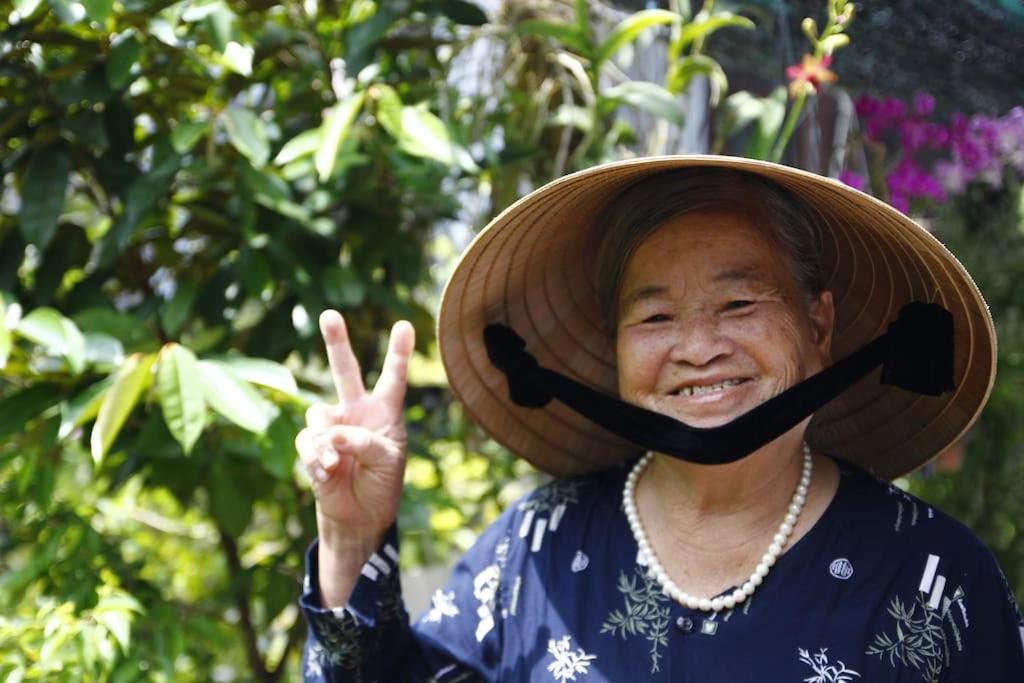 una mujer usando un sombrero de paja y un signo de paz en Charming Homestay, en Hoi An