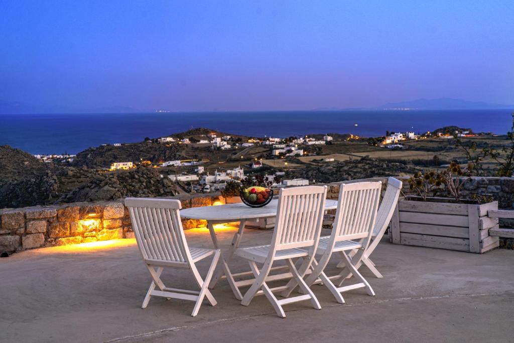 a table and chairs on a patio with the ocean at Oniropetra Apartments Mykonos in Plintri