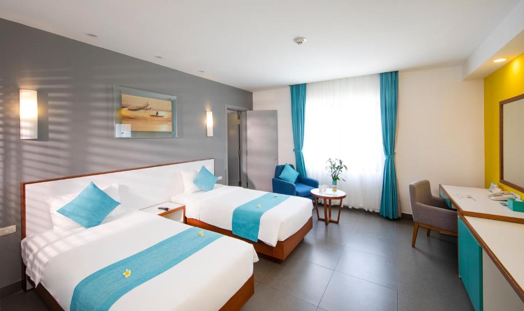 Postel nebo postele na pokoji v ubytování ÊMM Hotel Hoi An