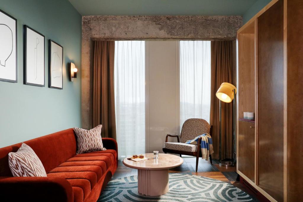 a living room with a couch and a table at The Hoxton, Brussels in Brussels